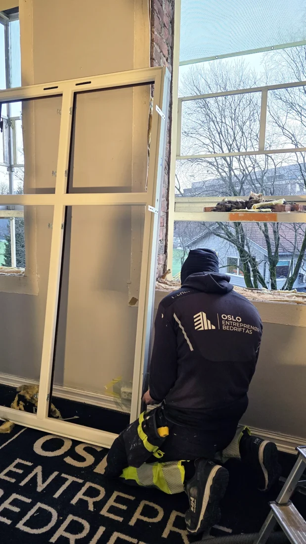 ansatt som skifter vinduer i gammel bygård